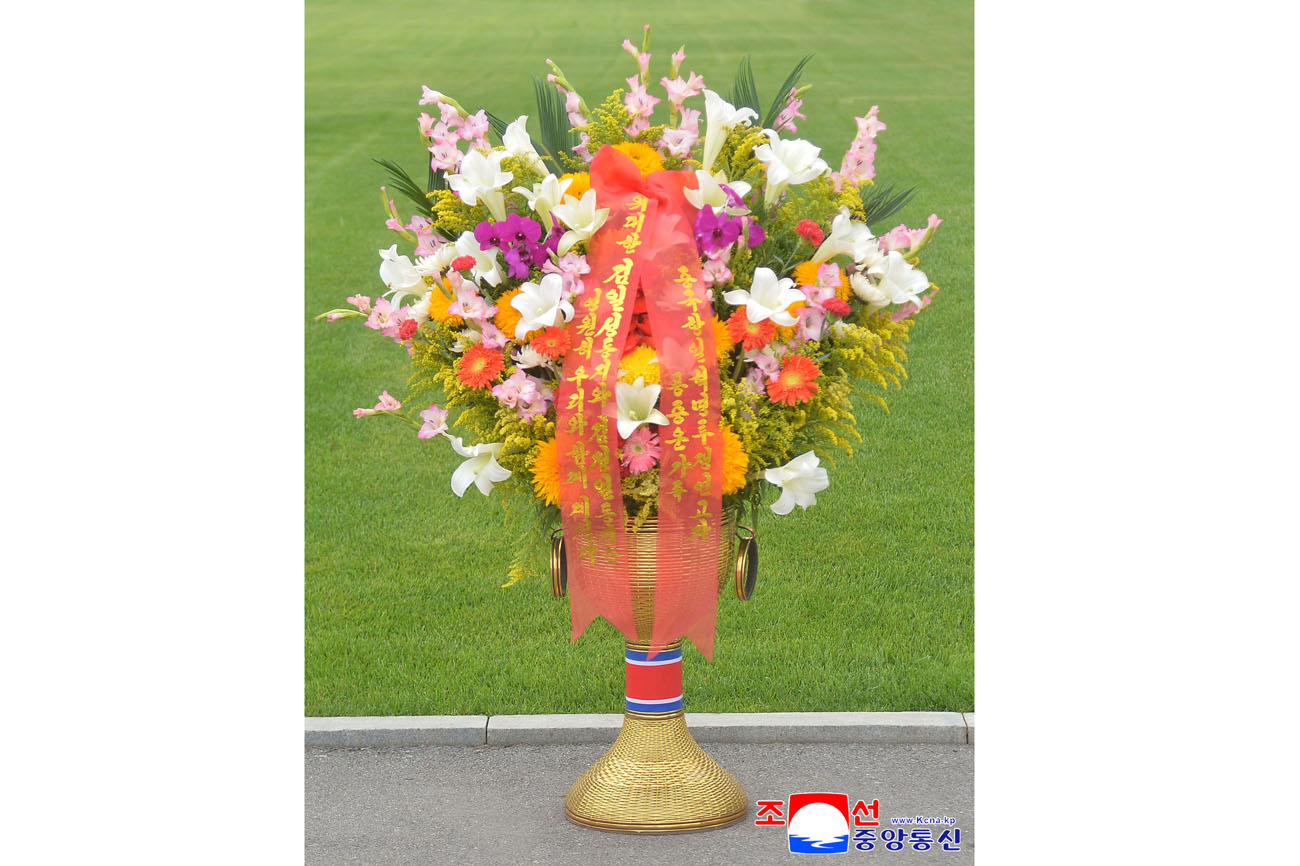 Floral baskets sent to bronze statues of great leaders Kim Il Sung and Kim Jong Il