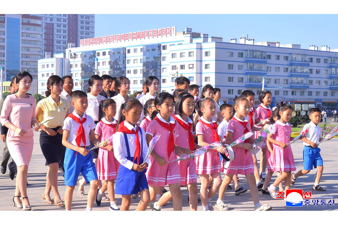 위대한 수령 김일성동지와 위대한 령도자 김정일동지의 동상에 일군들과 근로자들, 인민군장병들과 청소년학생들 꽃바구니 진정
