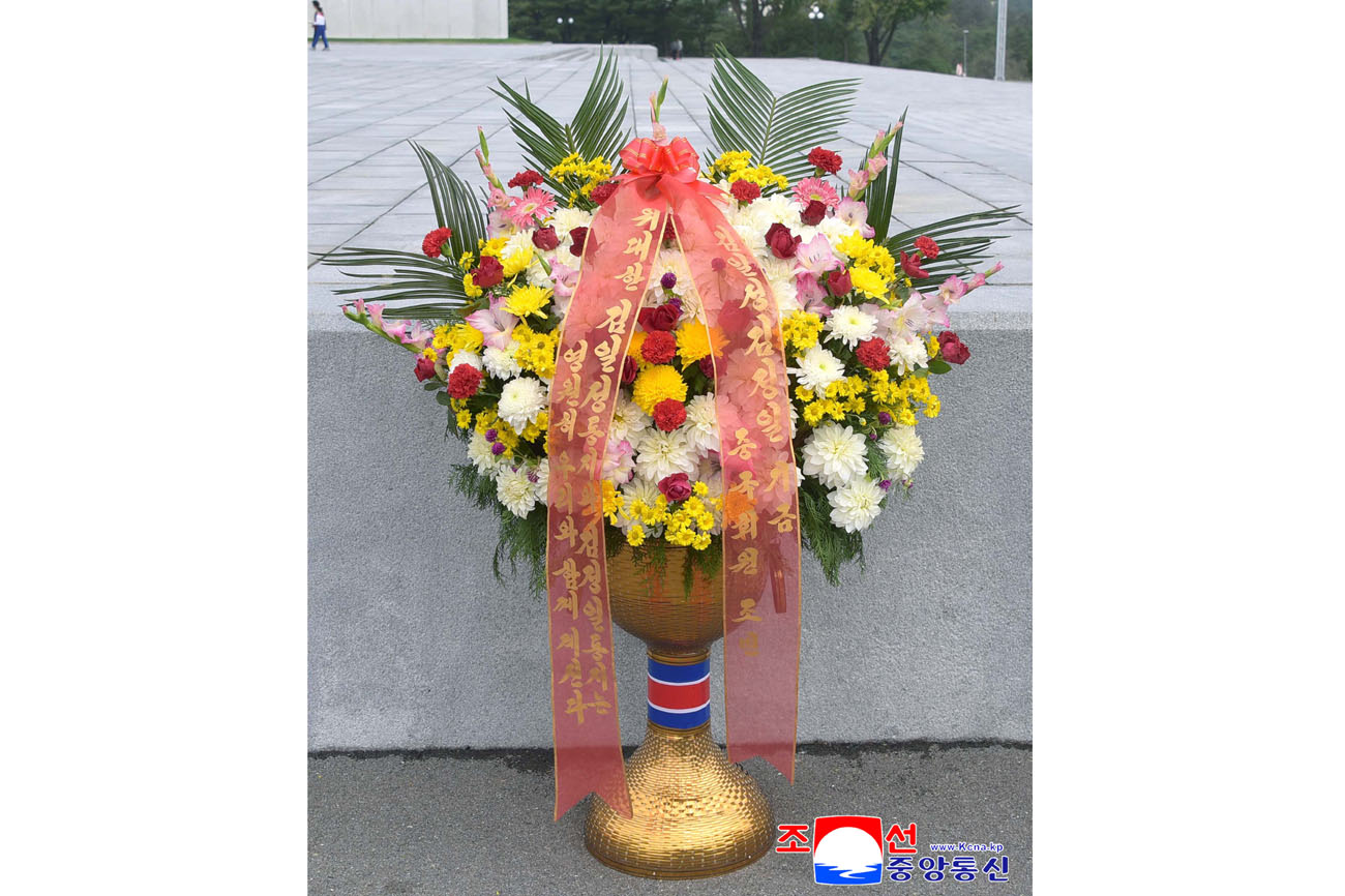 위대한 수령 김일성동지와 위대한 령도자 김정일동지의  동상에 김일성김정일기금 회원들이 꽃바구니를 드리였다