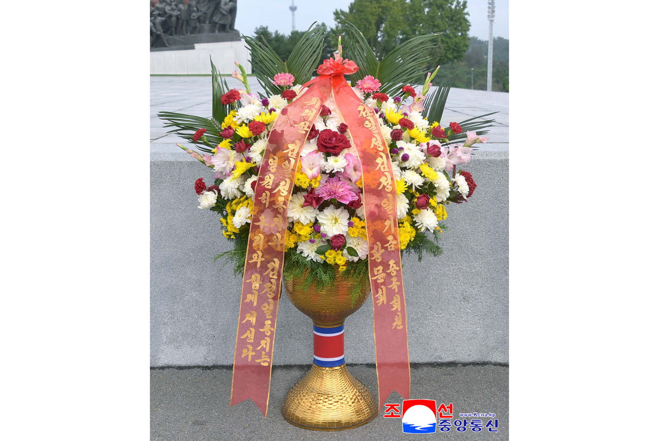 위대한 수령 김일성동지와 위대한 령도자 김정일동지의  동상에 김일성김정일기금 회원들이 꽃바구니를 드리였다