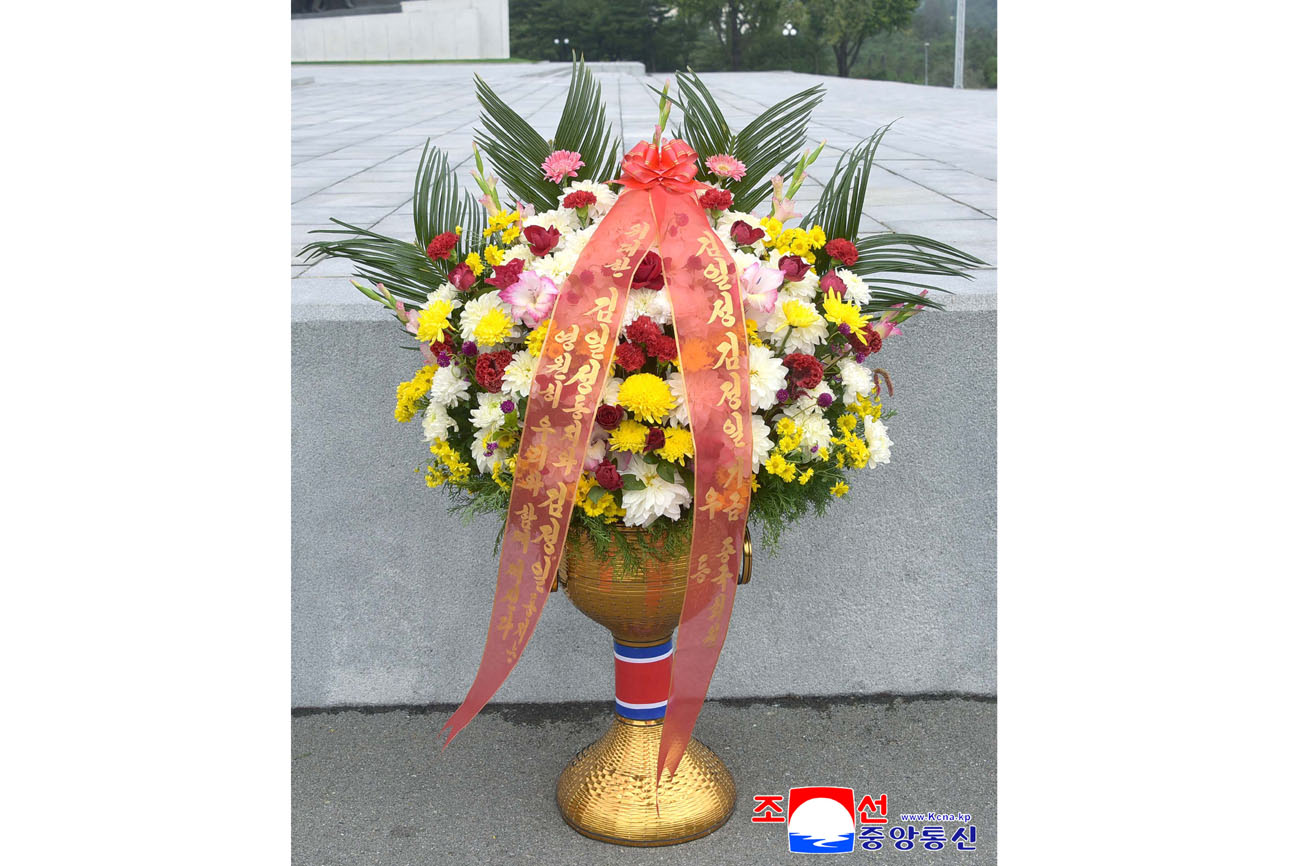 위대한 수령 김일성동지와 위대한 령도자 김정일동지의  동상에 김일성김정일기금 회원들이 꽃바구니를 드리였다