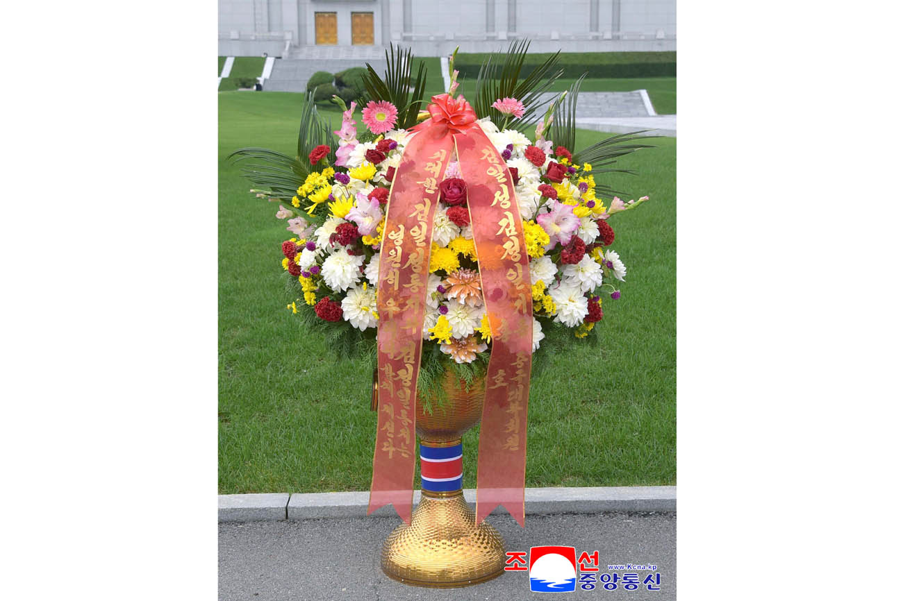 위대한 수령 김일성동지와 위대한 령도자 김정일동지의  동상에 김일성김정일기금 회원들이 꽃바구니를 드리였다