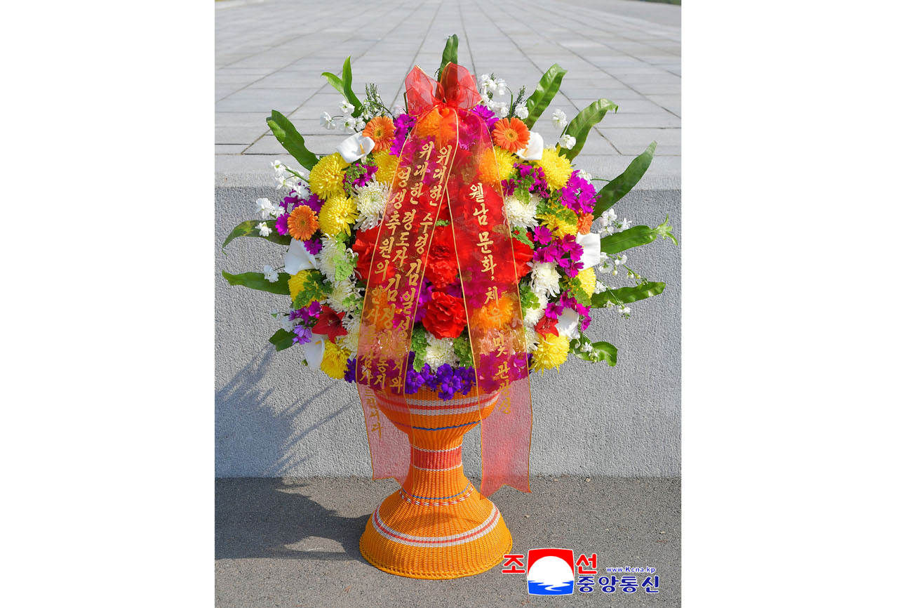 Floral baskets laid before bronze statues of great leaders Kim Il Sung and Kim Jong Il