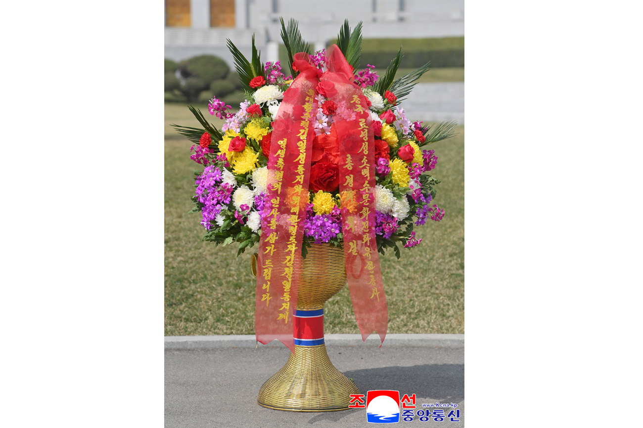 Floral baskets laid before bronze statues of great leaders Kim Il Sung and Kim Jong Il
